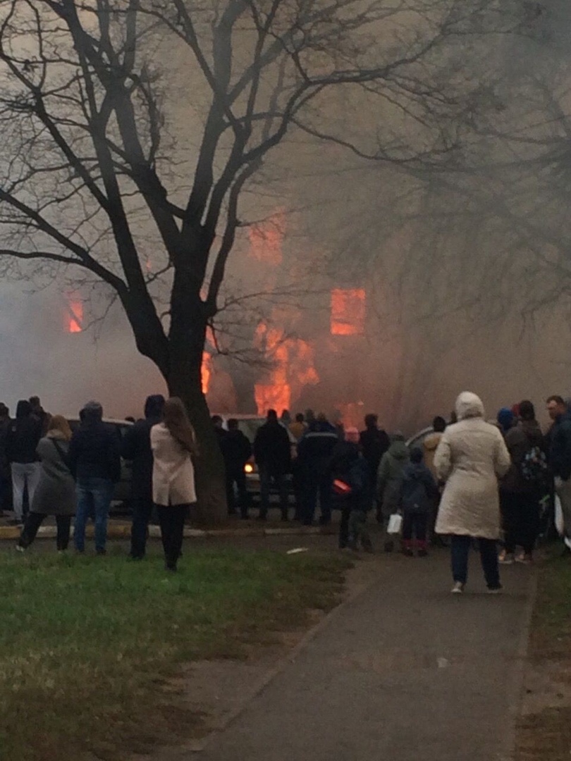 В Раменском горит дом, очевидцы отталкивают от него припаркованные автомобили.
